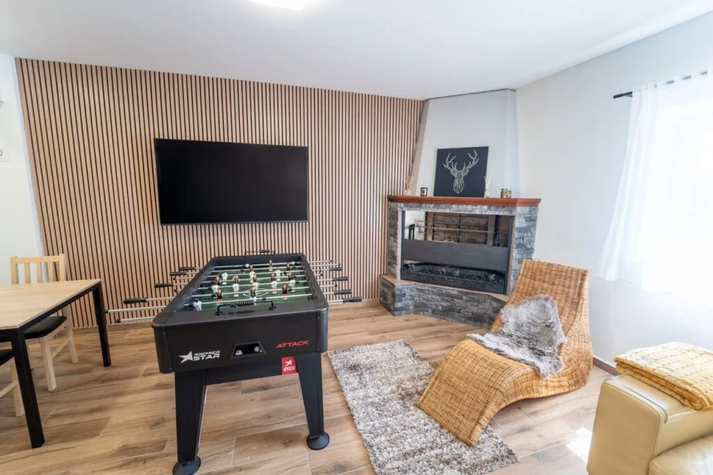 Společenská místnost s krbem a fotbálkem